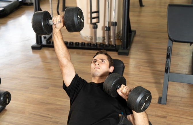 Atleta treinando com halteres em uma academia